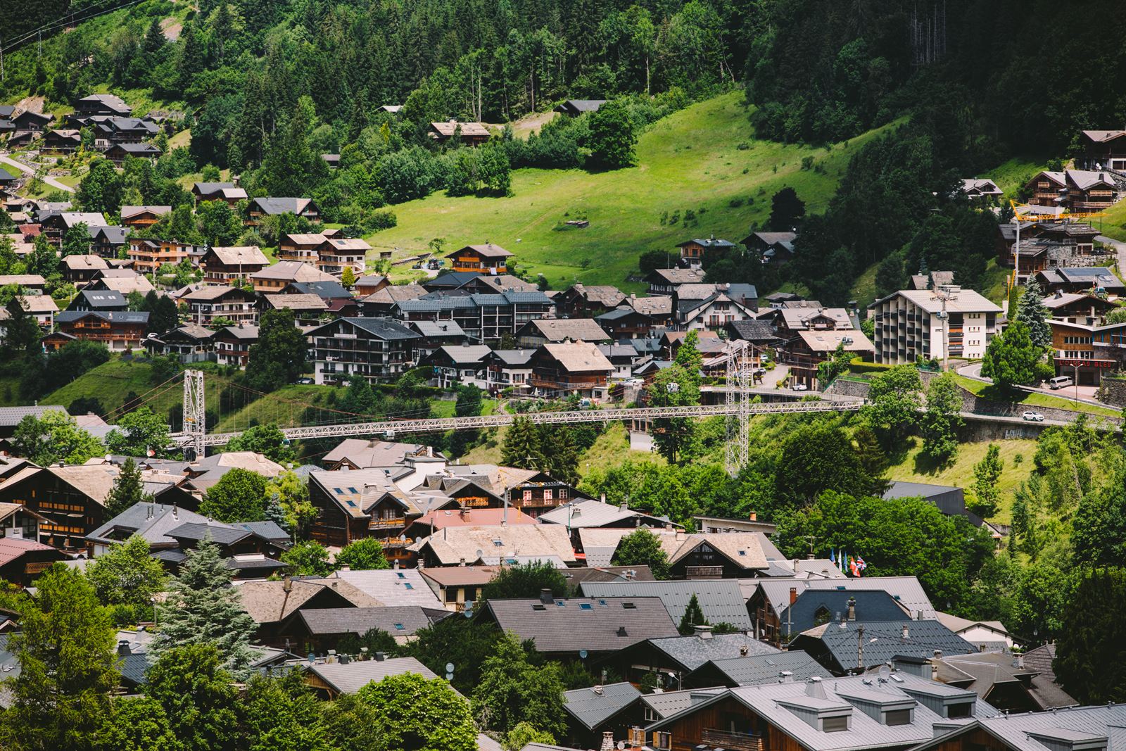 Chalets du village de Morzine en été, entourés d'alpages et de forêt